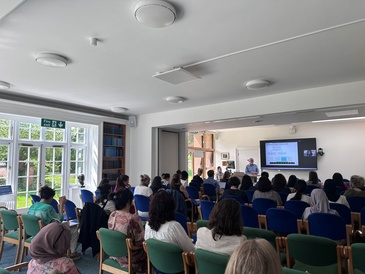 A crowd of people watching a lecture by Richard Bennett.